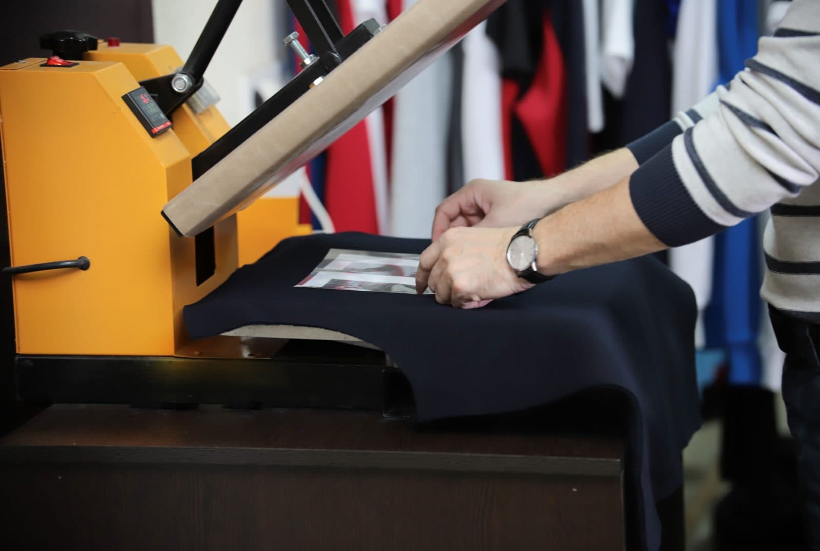Hands preparing a garment on a heat press